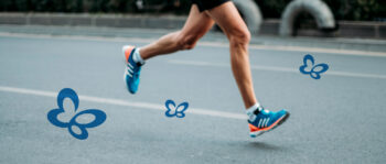 Beine eines Läufers auf der Straße mit Schmetterlingen