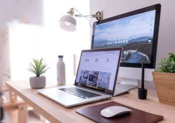 Macbook und Bildschrim auf modernem Schreibtisch